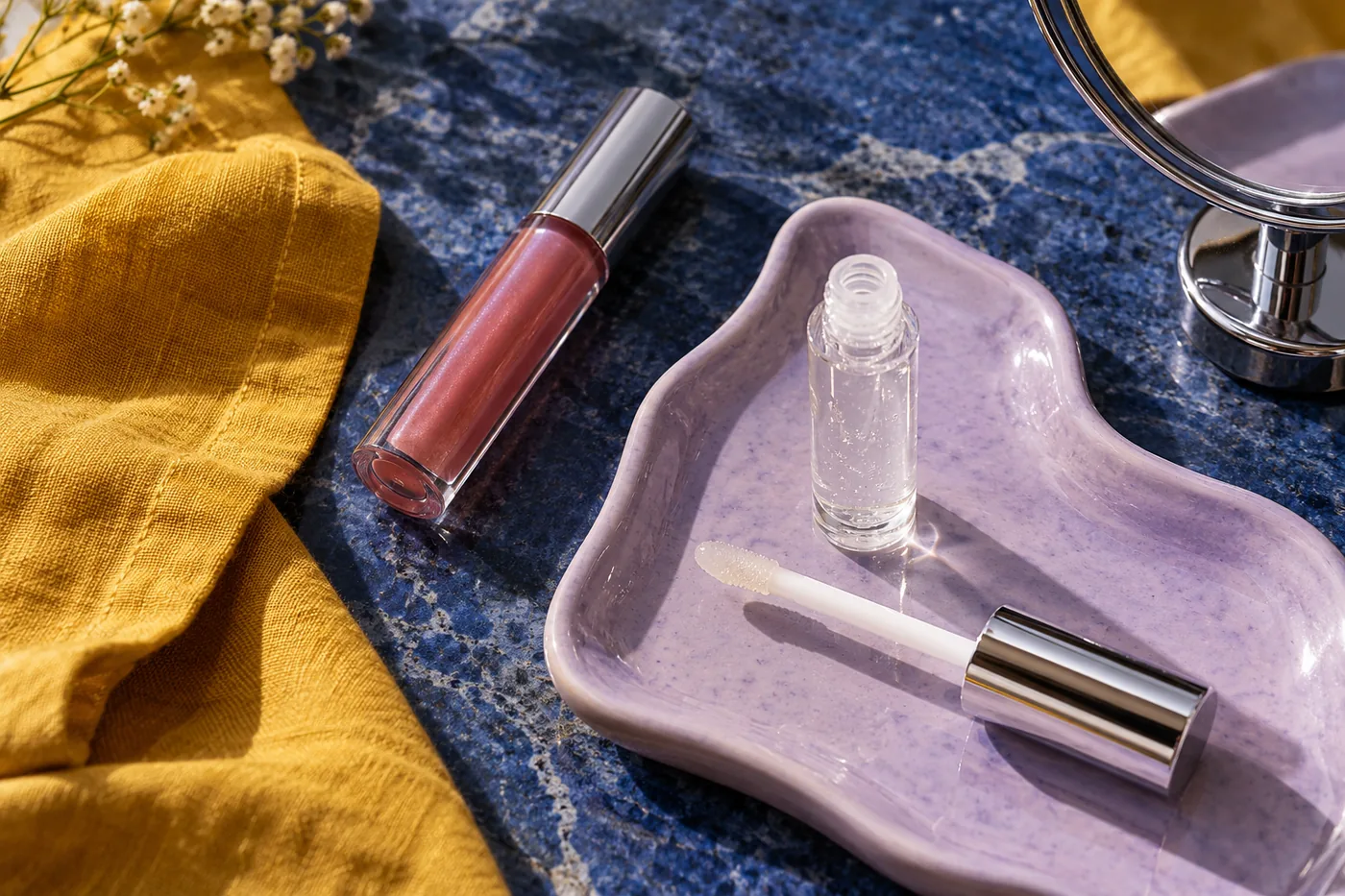 Gloss transparente e rosado com bandeja lilás, linho açafrão e espelho cromado sobre pedra azul cobalto