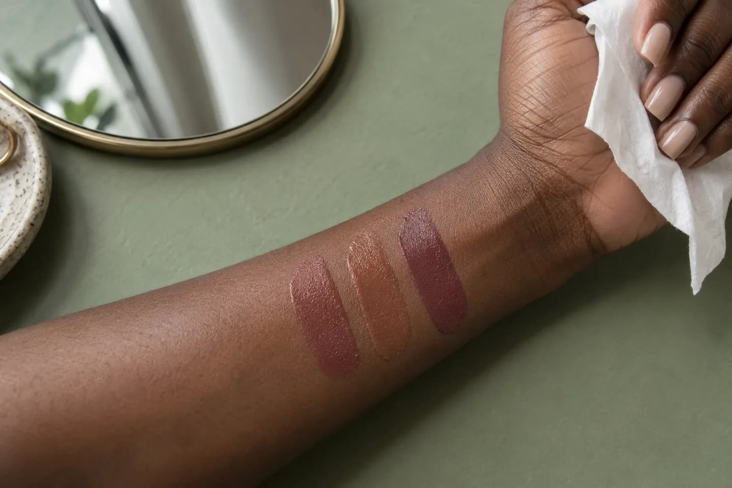 Rose-brown, warm caramel and muted plum lipstick swatches on deep brown skin